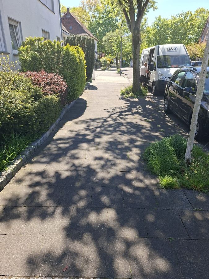 Gepflegter Gehweg mit Beeten vor einem Wohnhaus